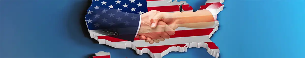 Handshake in front of a USA-shaped American flag