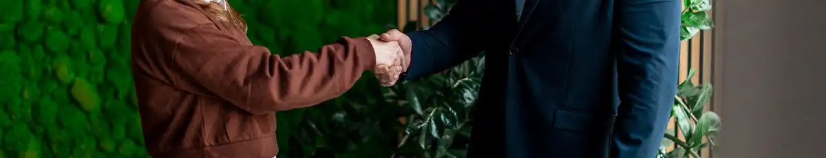 Close-up of a handshake in what appears to be a professional business setting
