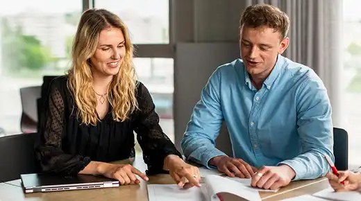 Two co-workers reviewing a document in front of them