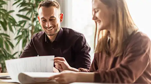 A team member points somtehing in a document out to another