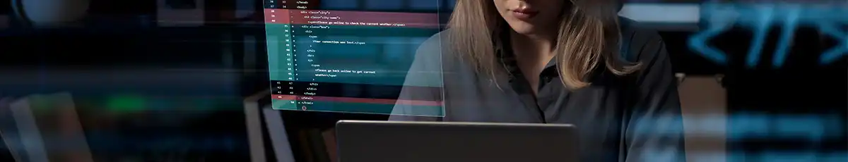 Employee sitting in front of her laptop, programming something