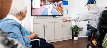 Older people playing video games in front of a TV