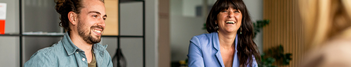 Employees smilingly talk to each other in an office