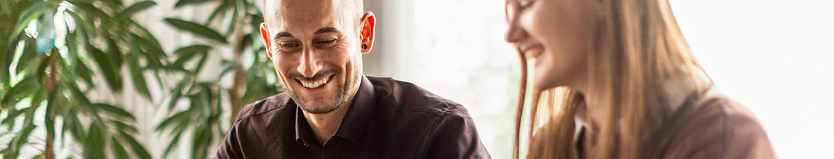 Mann und Frau lächelnd im Büro