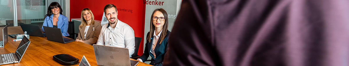 A person holds a presentation in front of a small group in an office setting.