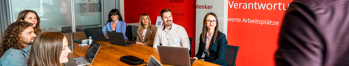 People in an office setting intently listen during a presentation.