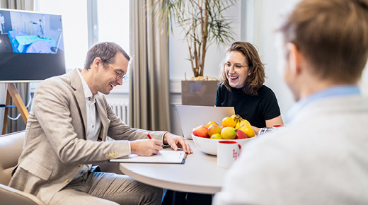 A group of three employees evaluates the results of usability testing in an office setting.