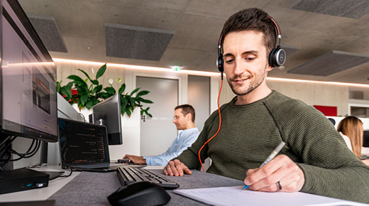 An employee wearing a headset takes notes.
